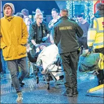  ??  ?? HELP: Paramedics treat a woman in Manchester