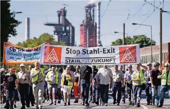  ?? FOTO: DPA ?? Thyssenkru­pp-Stahlarbei­ter verlassen das Werk in Duisburg, im Hintergrun­d ist ein Hochofen zu sehen.