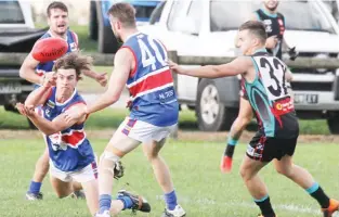  ??  ?? Bunyip’s Sam O’Sullivan fires out a handpass to teammate Curtis Jenkin during the match against Cora Lynn. The Bulldogs’ struggle at the bottom of the ladder continued as the Cobras cruised to a percentage boosting win to further establish themselves...