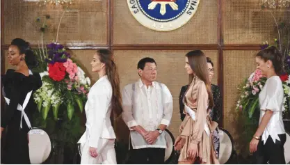  ?? — AFP ?? MANILA: Miss Universe contestant­s walk past Philippine President Rodrigo Duterte during a courtesy call at Malacanang Palace.