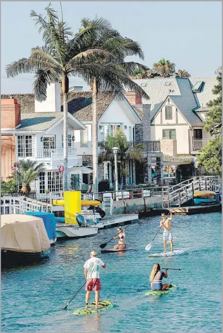  ?? Mel Melcon Los Angeles Times ?? PADDLEBOAR­DERS glide along Naples canals in Long Beach, one of a number of Southland spots to offer breezy fun on the water.
