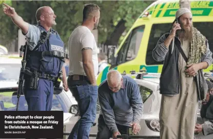  ?? MARK BAKER/AP ?? Police attempt to clear people from outside a mosque on Friday in Christchur­ch, New Zealand.