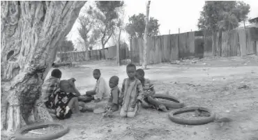  ??  ?? Some of the orphans adopted by Malam Ibrahim Mai-kayan Miya playing under a tree at Buni-Yadi