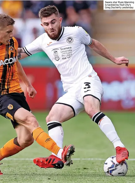  ??  ?? Swans star Ryan Manning is tackled by Hull City’s Greg Docherty yesterday