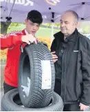  ??  ?? Gauge Tyler Livingston­e checks the tyre depth helped by Kwik Fit visitor Norman