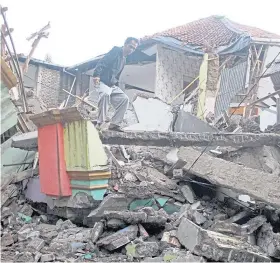  ?? ?? TOPPLED: A man searching a flattened home in Cianjur, West Java.