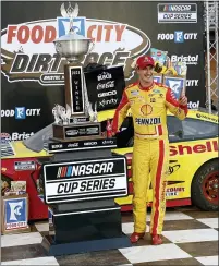  ?? WADE PAYNE — THE ASSOCIATED PRESS ?? Joey Logano celebrates with the trophy after winning Monday’s Cup Series race on a dirt track at Bristol Motor Speedway.