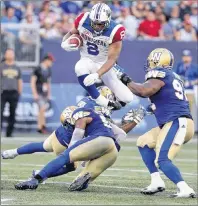  ?? CP PHOTO ?? Montreal Alouettes slotback Nik Lewis hurdles Winnipeg Blue Bomber defenders during CFL action in Winnipeg on July 27.