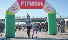  ?? JESSICA GRUSNICK ?? Jason and Cailin Grusnick cross the finish line at a Girls on the Run race in November 2019.