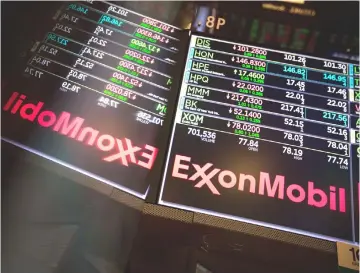  ??  ?? A monitor displays the Exxon Mobil logo on the floor of the New York Stock Exchange in New York on Apr 13.