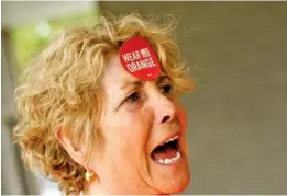  ??  ?? Judy Dale wears an orange sticker on her forehead during the Gun Violence Awareness Day event. Orange was chosen as the color to show support for victims of gun violence because it is the same color worn by hunters.