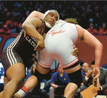  ?? ROB DICKER/DAILY SOUTHTOWN ?? Joliet Catholic’s Dillan Johnson holds on to Aurora Christian’s Braden Hunter during the 285-pound championsh­ip match of the Class 2A state meet at the University of Illinois’ State Farm Center in Champaign on Feb. 18.