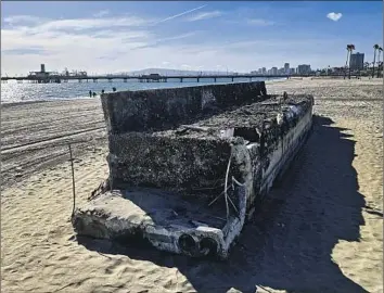  ?? Kelvin Kuo Los Angeles Times ?? AFTER STORMS last month, this slab of concrete was found on Junipero Beach. A Long Beach official believes it’s a piece of a dock and weighs between 1 and 2 tons. City workers were gradually moving it.