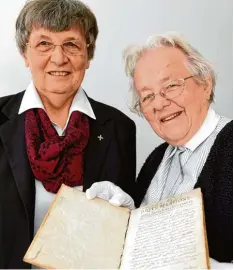  ??  ?? Mechtild Meckl, Oberin der Congregati­o Jesu, und Archivarin Schwester Clementine Nagel (r.) zeigen eine Biografie von Mary Ward, verfasst von Mary Poyntz.