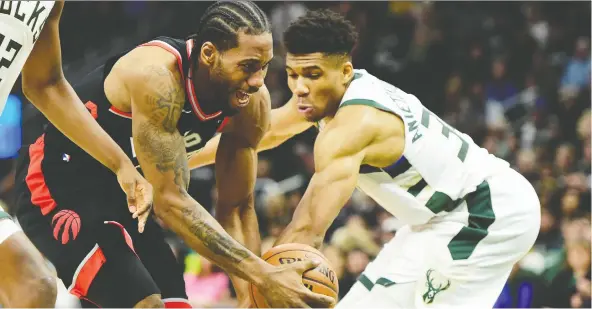  ?? FRaNK GUNN/THE CANADIAN PRESS ?? The Bucks’ Giannis Antetokoun­mpo, right, fouls the Toronto Raptors’ Kawhi Leonard during Friday’s Game 2 of the Eastern Conference final in Milwaukee.