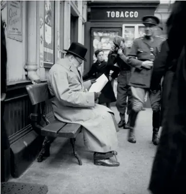  ??  ?? Winston Churchill reads a newspaper on the platform while waiting for a train at St Andrews during a trip to Scotland to visit Polish troops, inspect coastal defences and tour a Naval Establishm­ent in Fife in October 1940