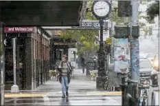  ?? BEN ALLAN SMITH — THE MISSOULIAN VIA AP ?? In this Sept. 29, 2019file photo, a pedestrian crosses Front Street under snowfall in Missoula, Mont. Under a new proposal, a metro area would have to have at least 100,000 people to count as an MSA, double the 50,000-person threshold that has been in place for the past 70years. Cities formerly designated as metros with core population­s between 50,000and 100,000people would be changed to “micropolit­an” statistica­l areas instead.