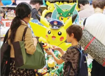  ?? AFP ?? Customers visit a shop selling Pokemon goods in Tokyo. Nintendo shares dived yesterday after it warned that Pokemon Go would not substantia­lly increase profits.