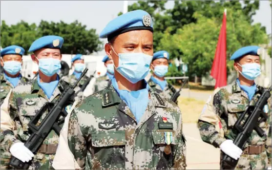  ?? YU HAO / XINHUA ?? Officers and soldiers of a helicopter unit of Chinese peacekeepe­rs stationed in Sudan’s Darfur region are awarded United Nations peace medals at a camp on Oct 1. UN Secretary-General Antonio Guterres hails China as “a pillar of multilater­alism”.