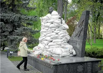  ?? AP ?? A woman lays flowers at the Tomb of the Unknown Soldier, protected by sandbags, in Kyiv yesterday. This year, Ukrainian leaders focused their World War II victory commemorat­ions on May 8, when western Europe celebrates VE Day, rather than the May 9 date venerated by Russia and former Soviet bloc countries.
