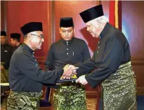  ??  ?? 11th CM: Mohd Khalil congratula­ting Adly (left) after the swearing in at Seri Negeri in Melaka. — Bernama