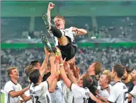  ?? AP FILE ?? Captain Bastian Schweinste­iger is hoisted by teammates after playing his final match for Germany last summer.