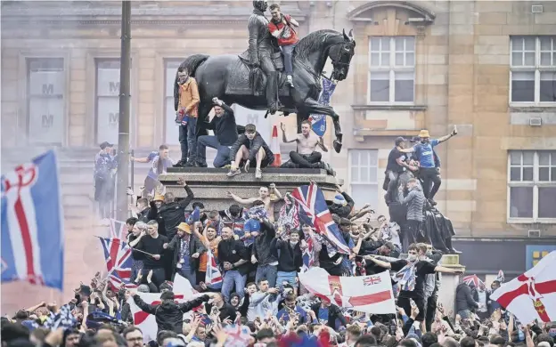  ?? ?? Rangers fans celebrate winning the Scottish Premiershi­p title at George Square on May 15, 2021, in Glasgow