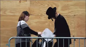  ?? Timothy A. Clary / AFP via Getty Images ?? Orthodox Jewish people not wearing face masks are seen in a Brooklyn neighborho­od on Monday in New York. New York Gov. Andrew Cuomo warned of growing coronaviru­s clusters in large Orthodox Jewish communitie­s around New York City.