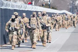  ?? JACQUELYN MARTIN/AP ?? National Guardsmen make their presence known Thursday near the U.S. Capitol. There were no signs of disturbanc­e despite evidence of a “possible plot” by a militia.