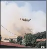  ??  ?? A plane drops water over a forest fire near the village of Ortale in Corsica.