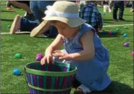  ??  ?? Lexi Beecher fills her basket with plastic eggs at the Great Schuylervi­lle Egg Hunt on Saturday.