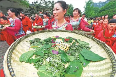  ?? LI ZHONG/ FOR CHINA DAILY ?? Performers carry bamboo trays with clay cats guarding silkworms during a ceremony celebratin­g the beginning of summer in Hangzhou, Zhejiang province, on Friday. Silkworms begin to grow rapidly after the beginning of summer in the solar calendar, while...