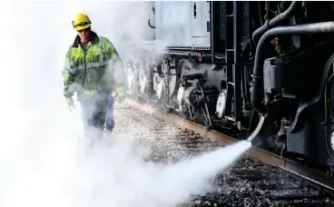  ?? Staff photo by Hunt Mercier ?? ■ A Union Pacific worker walks through a cloud of steam Tuesday after working on the company’s fully restored Big Boy steam locomotive No. 4014, which stopped for 45 minutes in Texarkana as part of an interstate tour.