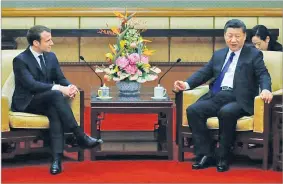  ??  ?? ANDY WONG/POOL/AFP French President Emmanuel Macron chats with his Chinese counterpar­t Xi Jinping during a meeting at the Diaoyutai State Guesthouse in Beijing.