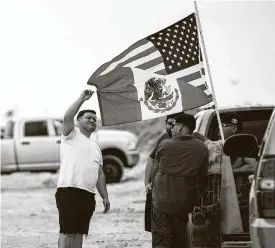  ?? Marie D. De Jesús / Staff photograph­er ?? Friends gather at Crystal Beach during Jeep Weekend on Sunday. The men said they are proud of their dual heritage, so they brought a flag that included parts of the Mexican flag and the American flag.