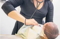  ?? AMR ALFIKY/AP ?? A pediatrici­an examines a newborn baby in her clinic in 2019 in Chicago. The American Academy of Pediatrics says it intends to eliminate “race-based” medicine.