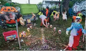  ??  ?? Son Brendon, 15, is turning on the lights of a Halloween display in the backyard of his home.