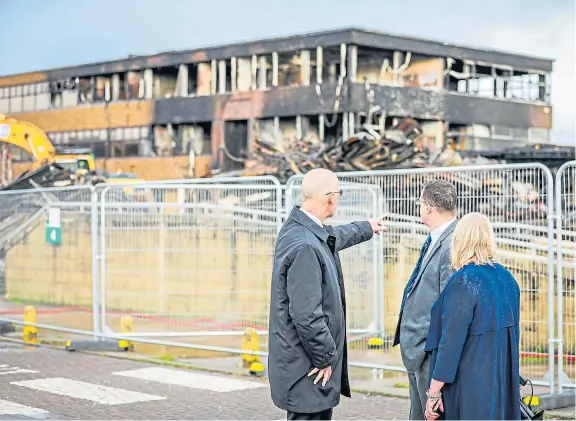 ?? Picture: Steve Brown. ?? Deputy First Minister John Swinney with Woodmill High School rector Sandy MacIntosh and Carrie Lindsay, executive director of Education and Child Services, at the site of the burned-out Woodmill building.