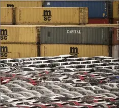  ?? AP photo ?? Cars for export and import are stored in front of containers Thursday at the harbor in Bremerhave­n, Germany, with 2 million vehicles per annum one of the largest automobile hubs in the world. President Donald Trump said Friday that he is delaying any decision to impose tariffs on car and auto-part imports for now.