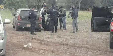  ??  ?? Agentes de investigac­iones y de la comisaría de la colonia Campo Agua’e durante la detención de los militares y el supuesto policía.