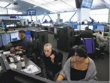  ?? Michael Macor / The Chronicle 2017 ?? Dispatcher­s Justin Wong (far left) and Joan Vallarino (center) with Kim Delara, a dispatch trainee, at the S.F. 911 call center.