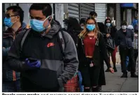  ??  ?? People wear masks and maintain social distance Tuesday while waiting in line outside a store in the Brooklyn borough of New York. (AP/Bebeto Matthews)