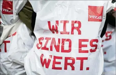  ??  ?? Ein Mitarbeite­r des öffentlich­en Dienstes trägt bei einer zentralen Streikkund­gebung ein Cape mit der Aufschrift „Wir sind es wert". Foto: Marcel Kusch, dpa