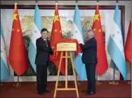  ?? (AP/Xinhua/Li Tao) ?? China’s Foreign Minister Qin Gang (left) and his Honduran counterpar­t, Enrique Reina, unveil the Honduras Embassy plate during the inaugurati­on of the embassy Sunday in Beijing.