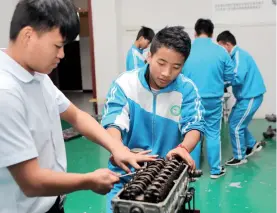  ??  ?? Le 26 septembre 2018, au lycée profession­nel du district de Qianxi, ville de Bijie (province du Guizhou), un atelier pratique dans un bâtiment d’usine en réparation appliquée et maintenanc­e automobile