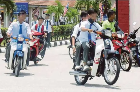  ??  ?? RAMAI pelajar tidak memakai topi keledar ketika menunggang
motosikal.