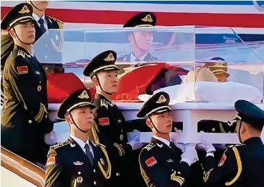  ?? Photos: CCTV ?? Troops carry Jiang Zemin’s casket down the steps from the plane that brought his body from Shanghai to Beijing.