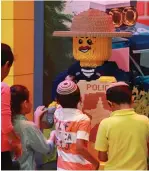  ?? (Ariel Shruster) ?? CHILDREN VISITING the park admire a giant Lego model of a policeman ‘minifigure.’