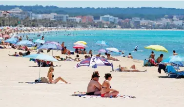  ??  ?? Return: Tourists on the beach in Palma, Majorca. Spain reopened its borders last week