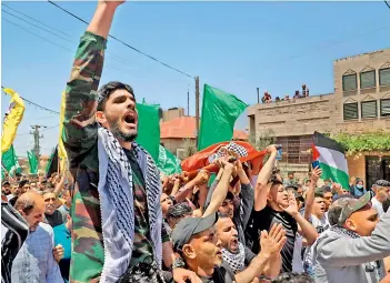  ?? AFP ?? Palestinia­ns wave the Hamas flag during the funeral of Rashid Abu Ara, 16, who was killed during clashes with Israeli troops in village of Aqaba near Nablus, in the north of the occupied West Bank, on Wednesday. —